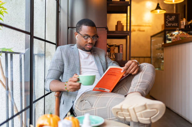 Man Reading Book in Cafe
